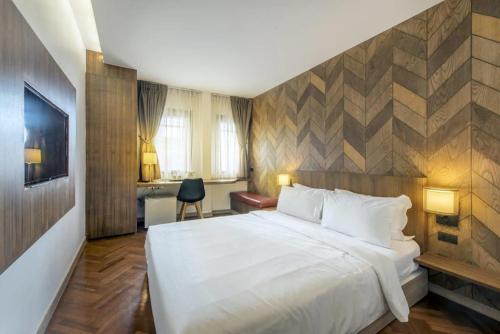 a hotel room with a large bed and a desk at The poshtel Bangkok By Benya BTS Phayathai in Bangkok