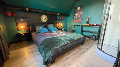 ein Schlafzimmer mit einem großen Bett in einem Zimmer mit grünen Wänden in der Unterkunft les nuits victoriennes in Saint-Germain-du-Corbéis