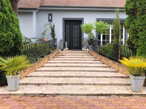 un escalier en pierre menant à une maison avec une porte noire dans l'établissement les nuits victoriennes, à Saint-Germain-du-Corbéis
