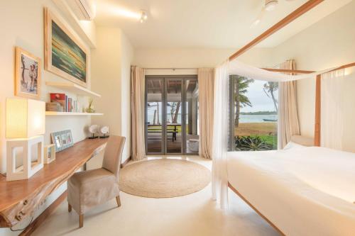 a bedroom with a desk and a bed and a window at Villa Cambresi by muse villas in Trou dʼ Eau Douce