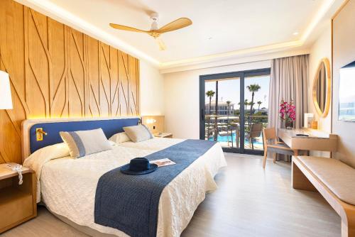 um quarto de hotel com uma cama com um chapéu em Hipotels Barrosa Palace & Spa em Chiclana de la Frontera