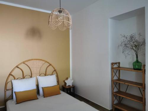 - une chambre avec un lit avec deux oreillers et un lustre dans l'établissement L'althea, à Carcassonne