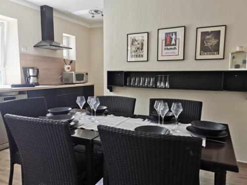 - une salle à manger avec une table, des chaises et des verres à vin dans l'établissement L'althea, à Carcassonne