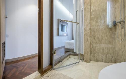 a bathroom with a shower with a glass door at The poshtel Bangkok By Benya BTS Phayathai in Bangkok