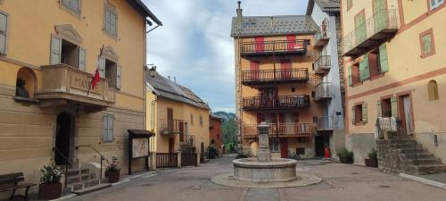 une ruelle avec une fontaine au milieu de deux bâtiments dans l'établissement 2 Pieces indépendant Peone-Valberg, à Péone