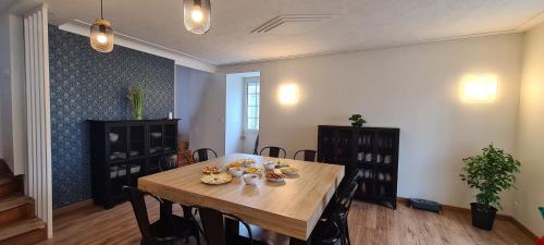 une salle à manger avec une table et des chaises en bois dans l'établissement Le Bocage gîte 90m2 chaleureux à 4 min du Puy du Fou, aux Épesses