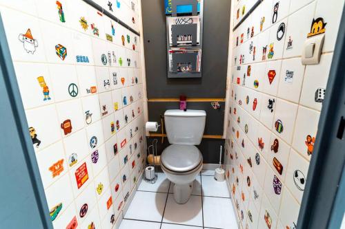 La salle de bains est pourvue de toilettes avec des étiquettes murales. dans l'établissement T4 spécial groupe, à Lyon