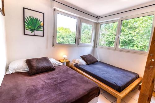 deux lits dans une chambre avec deux fenêtres dans l'établissement T4 spécial groupe, à Lyon