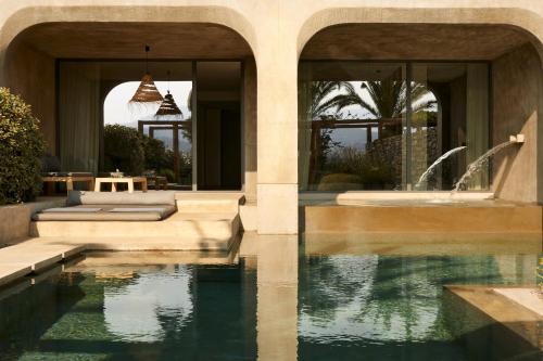 una casa con piscina di fronte a una casa di Minos Palace Hotel & Suites - Adults Only ad Ágios Nikólaos
