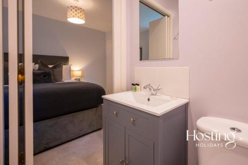 a bathroom with a sink and a bed and a mirror at Walkers Lodge In The Heart Of The Chilterns With Incredible Views in Henley on Thames