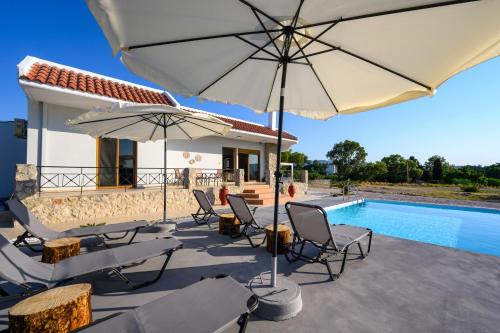 a patio with chairs and umbrellas next to a pool at El Paradiso in Pastida