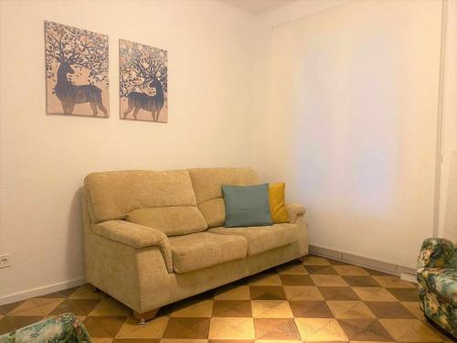 a living room with a couch and two paintings at Apartamento Catedral in Pamplona