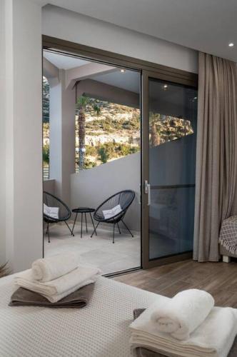 a bedroom with a bed and a patio with chairs at Kayy Apartments 3 in Matala in Matala