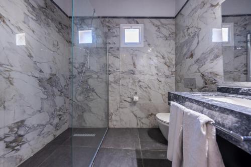 a bathroom with a shower and a toilet and a sink at La Regina Veneziana in Mağusa