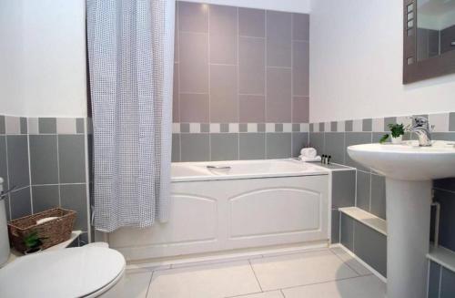 a bathroom with a tub and a toilet and a sink at Bristol Short Stays College Green, 2 Bed Parking in Bristol