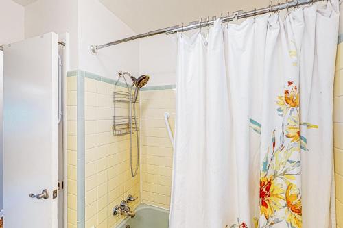 - un rideau de douche dans la salle de bains pourvue d'une baignoire dans l'établissement Paws & Relax Getaway, à Nashville