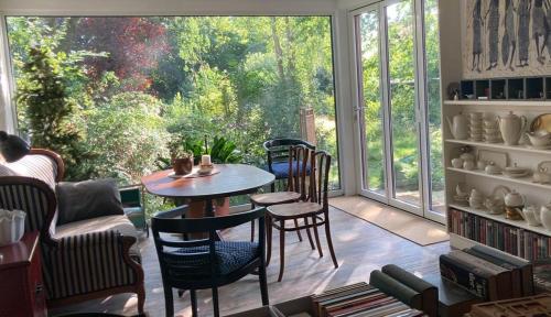 a room with a table and chairs and a large window at FeWo Olga Behrends in Wiesmoor