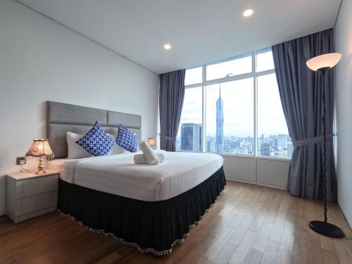 a bedroom with a large bed with a large window at Yemala Suites at Vortex KLCC in Kuala Lumpur