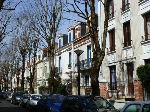 uma rua com carros estacionados em frente aos edifícios em Appartement au calme T3 RDC - Quartier de France em Vichy