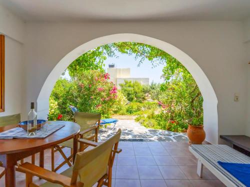 un arco en un patio con mesa y sillas en Maistros House - Walk To Beach - AC WIFI, en Frangokastello