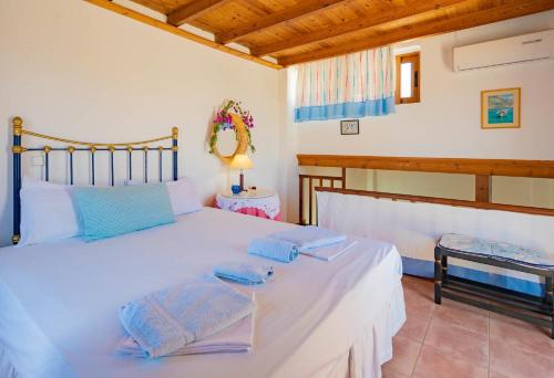 1 dormitorio con 1 cama blanca grande y toallas. en Maistros House - Walk To Beach - AC WIFI, en Frangokastello