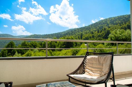 een stoel op een balkon met uitzicht op een berg bij Relax View Ap with Private Parking in Sinaia