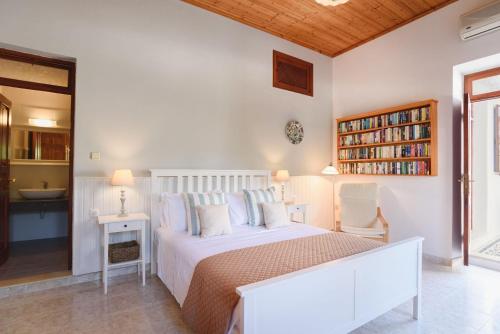 a bedroom with a white bed and a book shelf at Welcoming Rhodes Villa 2 Bedrooms Villa Thea Stunning Sea and BBQ Lindos in Lindos