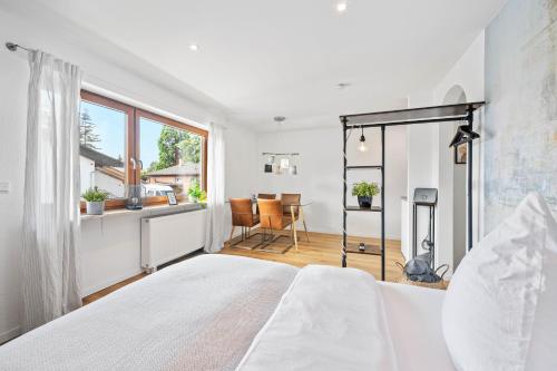 ein weißes Schlafzimmer mit einem Bett und einem Tisch in der Unterkunft Ruhiges und zentrales Apartment in Hüttenfeld in Lampertheim