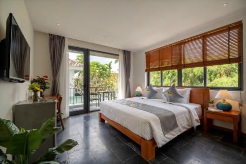 ein Schlafzimmer mit einem großen Bett und einem Balkon in der Unterkunft Em's House Hoi An Homestay in Hoi An