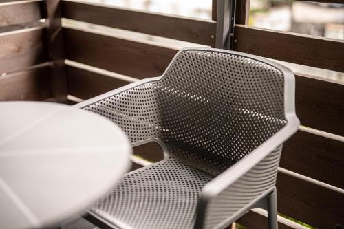 a metal chair and a table on a porch at Arya Alpine Lodge in Selva di Val Gardena