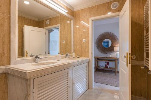 a bathroom with a sink and a mirror at Windmill Beachfront Villa in Colares