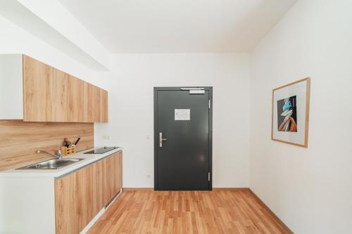 a kitchen with a black refrigerator in the corner at Central City Suits in Wiener Neustadt