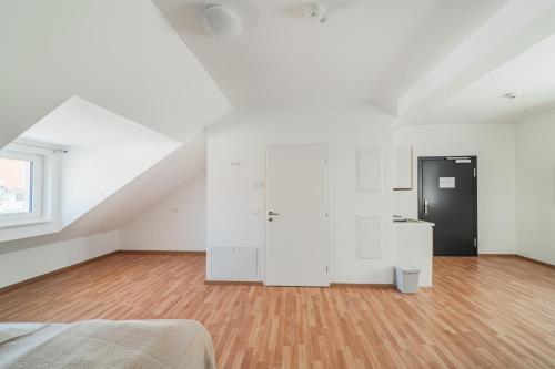 a bedroom with white cabinets and a wooden floor at Central City Suits in Wiener Neustadt