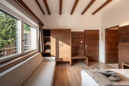 a bedroom with a bed and a window at Arya Alpine Lodge in Selva di Val Gardena