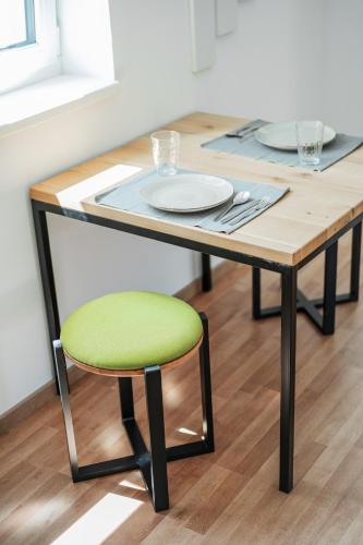 a wooden table with a green chair at a table at Central City Suits in Wiener Neustadt