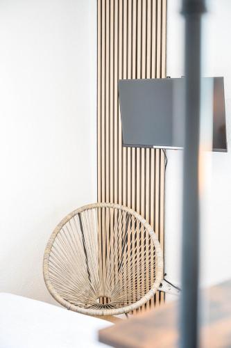 a wicker chair sitting next to a lamp at Ruhiges und zentrales Apartment in Hüttenfeld in Lampertheim