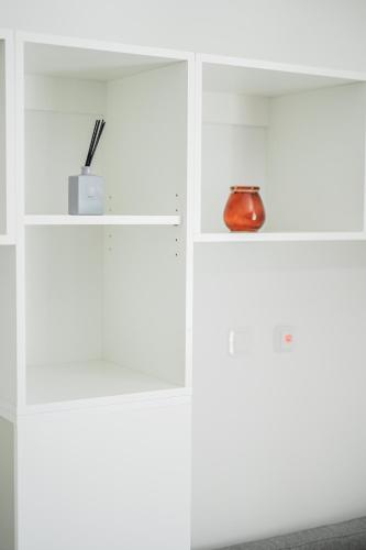 a white cabinet with a vase on top of it at Central City Suits in Wiener Neustadt