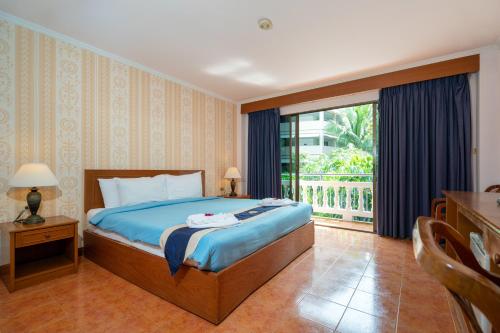 a bedroom with a bed and a large window at Patong Central Hotel & Apartment in Patong Beach