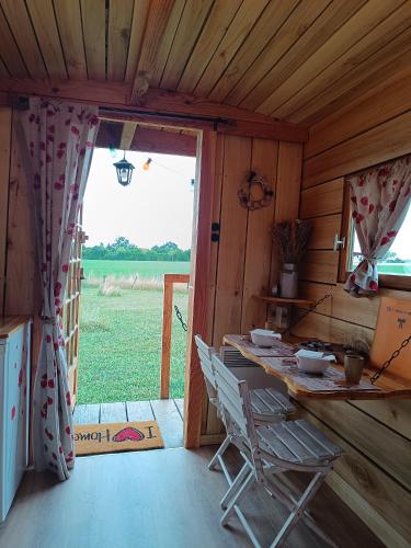 a room with a table and a chair in a cabin at Roulotte Ô Rêves Atypiques in Boucé