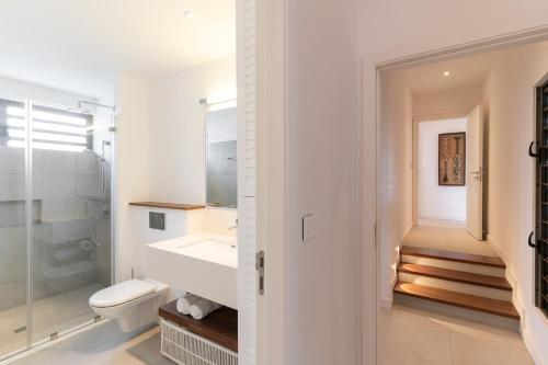 a white bathroom with a sink and a toilet at Villa Saphir by muse villas in Bambous
