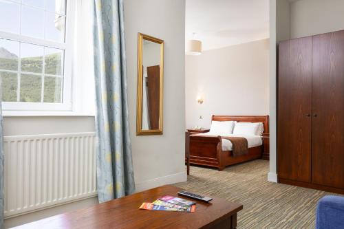 a hotel room with a bed and a table and a window at Arrochar Hotel 'A Bespoke Hotel' in Arrochar