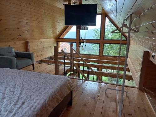 Brvnare Libero TARA في Sekulić : غرفة نوم بسرير ونافذة كبيرة