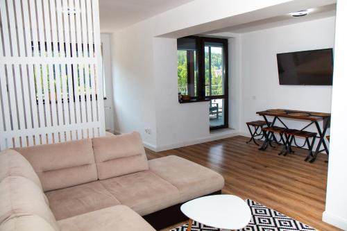 un soggiorno con divano e tavolo di Best View Ap with Parking And 2 Bathrooms a Sinaia