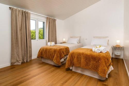 a bedroom with two beds with stuffed animals on them at Fénix House in Arco da Calheta