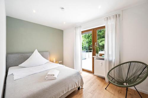 a bedroom with a bed and a chair and a window at Casa Tortuga - Ruhige 3 Zimmer Wohnung in Hüttenfeld in Lampertheim