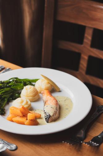 a plate of food with fish and vegetables on a table at Arrochar Hotel 'A Bespoke Hotel' in Arrochar
