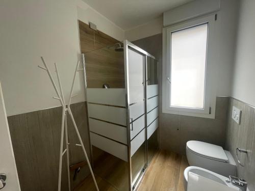 a bathroom with a toilet and a window at Appartamento Miramare in Rimini