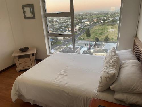 un grande letto in una stanza con una grande finestra di B1001 Ocean View a Bloubergstrand