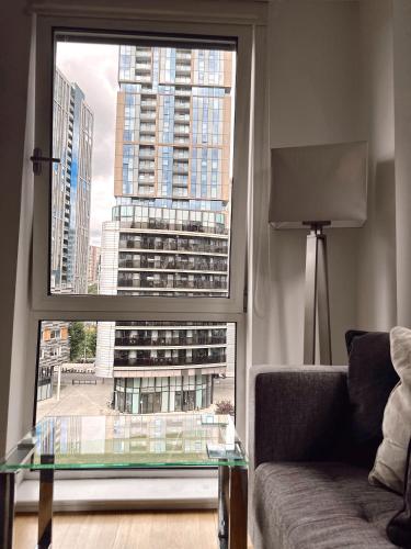 a living room with a glass table and a large window at Canary Wharf - Luxury Apartments in London