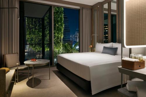 a bedroom with a bed and a large window at Pan Pacific Orchard in Singapore